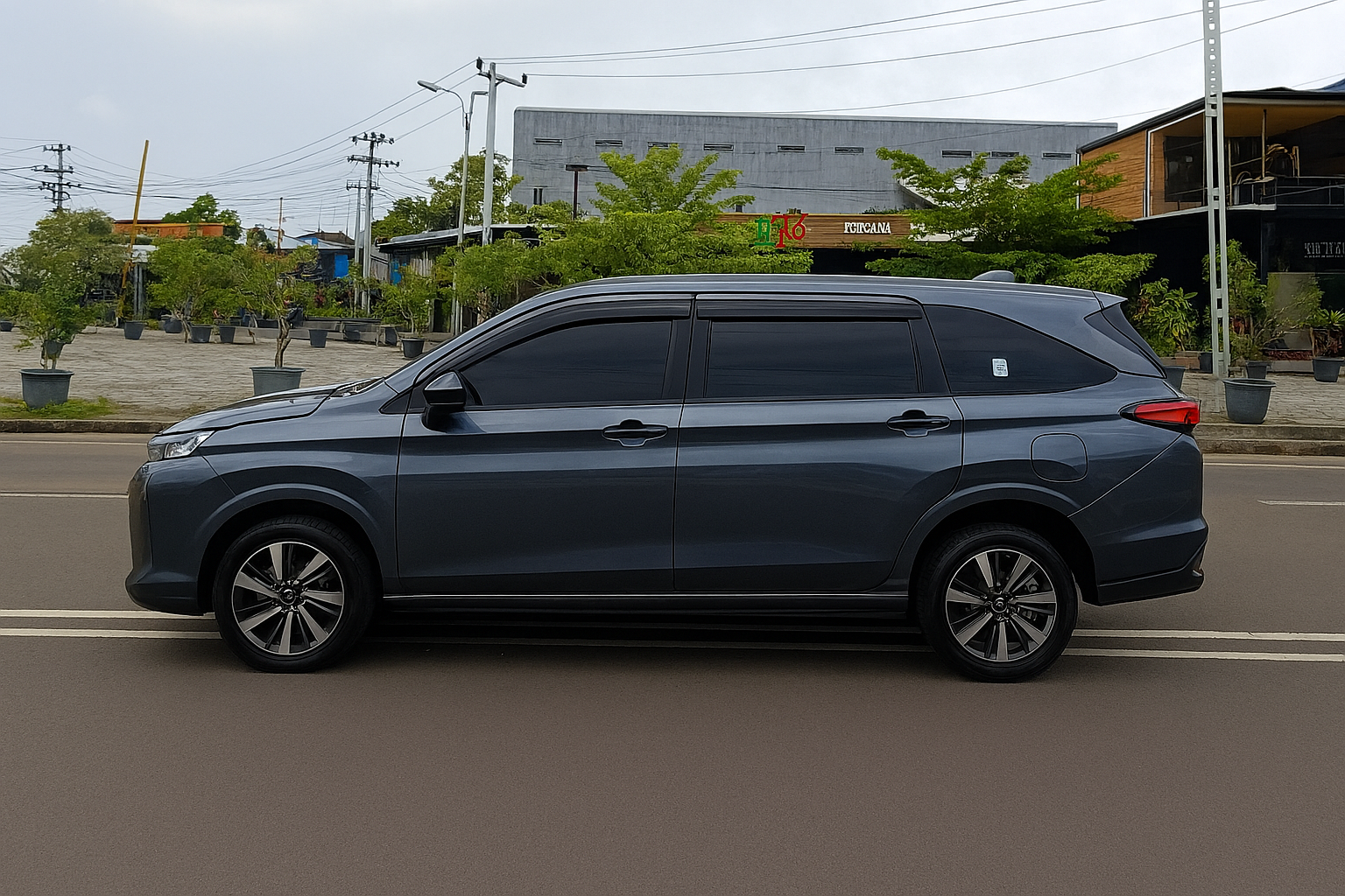 Toyota Avanza warna abu-abu gelap terparkir di jalan kota Medan, siap untuk layanan rental mobil Bandara Kualanamu.