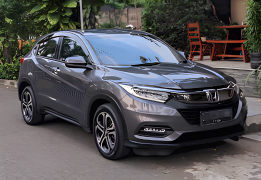 Honda HR-V warna putih difoto dari sudut depan samping, menampilkan desain compact SUV dengan grille depan hitam glossy solid tanpa banyak garis krom, headlamp LED tajam menyatu dengan lampu sein, serta velg alloy dua warna (dual-tone) yang sporty. Sebagai armada sewa mobil di Medan, HR-V menjadi pilihan SUV bergaya untuk pasangan, keluarga kecil, atau perjalanan bisnis yang mengutamakan tampilan elegan dan handling nyaman, baik untuk dalam kota maupun perjalanan ke luar kota seperti Berastagi.