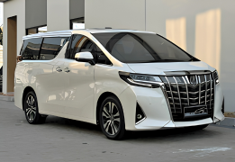 Toyota Alphard warna bronze/gold metalik generasi terbaru difoto dari sudut depan samping, menampilkan desain grille depan besar dan mewah dengan pola mesh unik, headlamp LED tajam menyatu dengan garis body, sliding door elektrik, serta interior kabin VIP yang identik dengan kenyamanan kelas atas. Sebagai armada paling premium sewa mobil di Medan, Alphard menjadi pilihan utama untuk jemputan tamu VVIP, wedding car mewah, rombongan pejabat/eksekutif perusahaan, hingga perjalanan bisnis kelas atas yang mengutamakan privasi dan kenyamanan maksimal.