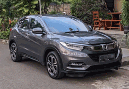 Honda HR-V warna putih difoto dari sudut depan samping, menampilkan desain compact SUV dengan grille depan hitam glossy solid tanpa banyak garis krom, headlamp LED tajam menyatu dengan lampu sein, serta velg alloy dua warna (dual-tone) yang sporty. Sebagai armada sewa mobil di Medan, HR-V menjadi pilihan SUV bergaya untuk pasangan, keluarga kecil, atau perjalanan bisnis yang mengutamakan tampilan elegan dan handling nyaman, baik untuk dalam kota maupun perjalanan ke luar kota seperti Berastagi.