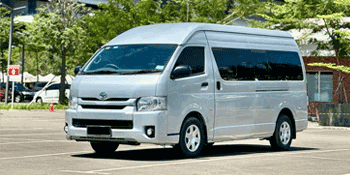 Gambar mobil Toyota Hiace yang siap untuk layanan rental, cocok untuk kebutuhan travel dan wisata.