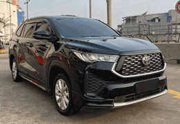 Toyota Hiace High Grade warna putih difoto dari sudut depan samping, menampilkan bodi van panjang dengan kapasitas besar, kaca jendela lebar di setiap baris kursi, dan desain grille depan yang tegas. Sebagai armada sewa mobil di Medan, Hiace menjadi pilihan utama untuk rombongan besar seperti study tour, rombongan wisata ke Danau Toba/Berastagi, antar-jemput bandara Kualanamu, hingga acara pernikahan dan perusahaan yang membutuhkan kapasitas hingga 15 penumpang